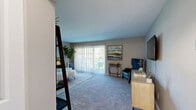This well-appointed 2-bedroom, 1-bathroom single-floor home at 229 Parkwood Dr in Lansing, Michigan offers a thoughtfully designed layout across a comfortable footprint. The living room serves as the heart of the home, featuring plush carpeting, neutral toned walls, and a large sliding glass door that floods the space with natural light while providing direct access to an outdoor patio with greenery views. Adjacent to the living room, the dedicated dining room is finished with wood-style flooring, a ceiling fan with light fixture, and a pass-through connection to the kitchen, creating an open and functional flow. The kitchen is outfitted with crisp white shaker cabinetry, light granite-style countertops, stainless steel appliances including a refrigerator, electric range, and dishwasher, all complemented by wood-style flooring. Both bedrooms are carpeted and feature large windows with vertical blinds that invite natural light, with the primary bedroom offering a closet and generous space. The shared bathroom includes a white vanity with stone-look countertop, a tub-shower combination with large-format gray tile surround, and wood-style flooring. A hallway connects all rooms, completing this practical and comfortable single-level home.