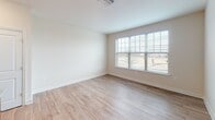 Located in Building D at 5234 Black Locust Drive in Frederick, Maryland, Unit 402 is a thoughtfully designed single-floor residence that blends functional layout with clean, contemporary finishes. The open-concept living and dining area features light wood-look flooring, neutral walls, and large windows fitted with blinds that invite an abundance of natural light while offering views of the surrounding neighborhood. The kitchen serves as a central hub of the unit, showcasing warm honey-toned cabinetry with sleek hardware, light granite countertops, a central island ideal for meal prep or casual dining, recessed lighting, and black appliances including a refrigerator, gas range, and dishwasher. A double stainless steel sink is set beneath additional upper cabinetry, maximizing storage. The bedroom features plush wall-to-wall carpeting, neutral tones, and a window with blinds, creating a calm and restful retreat. The bathroom is appointed with wood-toned cabinetry, a white countertop vanity, light wood-look tile flooring, and a tub and shower combination equipped with grab bars. Throughout the unit, consistent use of warm neutrals and quality materials contributes to a cohesive, welcoming ambiance well-suited for comfortable everyday living.