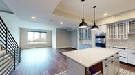 Located at 2220 Westcreek Ln in Houston, TX, this contemporary multi-story residence spans three thoughtfully designed floors. Rich hardwood flooring flows throughout, complemented by a clean, neutral palette and modern finishes. The entry level offers generous living space anchored by an open staircase with sleek black metal railings. The main living floor showcases a stunning open-plan kitchen and living area, where white shaker-style cabinetry with glass inserts, a bold blue-accented island, pendant lighting, stainless steel appliances, and a decorative tile backsplash create a refined culinary hub. Two well-proportioned bedrooms feature ceiling fans, large windows that invite abundant natural light, and views of the surrounding cityscape. Closets are outfitted with adjustable shelving systems for optimized storage. Three bathrooms are elegantly appointed with marble-look tile flooring, subway-tiled walk-in showers, and matte black hardware. A dedicated laundry room with in-unit Whirlpool washer adds everyday convenience. The crown jewel is the expansive rooftop patio, finished in large-format stone tile and equipped with a built-in outdoor grill station, a ceiling fan, and sweeping Houston skyline views — an exceptional outdoor entertaining space.