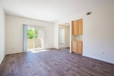Located at 802 Camino Ramon in Danville, CA, this single-floor 2-bedroom, 1-bathroom residence offers a clean, functional layout with a neutral color palette throughout. The open-concept kitchen and living room form the heart of the space, where warm honey-toned wood cabinetry pairs with granite countertops, a double stainless steel sink, recessed lighting, and white appliances including a range, dishwasher, microwave, and refrigerator. A peninsula counter connects the kitchen to the living area, creating an ideal space for casual dining or entertaining. The living room features wood-style plank flooring and a sliding glass door that opens to a private balcony, filling the room with natural light and outdoor views. A dedicated dining or utility cabinet area with overhead storage adds additional functionality adjacent to the living space. Both bedrooms are carpeted for comfort and feature crisp white walls, offering a calm and restful atmosphere. The primary bedroom includes a sliding-door closet with built-in shelving. A shared full bathroom is appointed with a wood-vanity, a combined tub and shower, and wood-style tile flooring. Connecting hallways provide a logical flow throughout the residence, completing this thoughtfully arranged home.