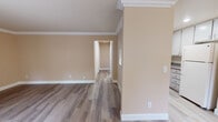 Located at 31 Heritage Village Lane in Campbell, CA, this single-level residence offers a thoughtfully designed layout finished with consistent warm neutral tones throughout. Crown molding frames each room, adding a refined architectural detail that elevates the overall aesthetic.

The living room serves as the central gathering space, featuring wood-look flooring, a fireplace flanked by built-in shelving, and a sliding glass door that fills the room with natural light while providing direct access to an outdoor patio. Adjacent to the living area, the dining space includes a ceiling fan with light fixture and opens conveniently to the kitchen, which is equipped with white cabinetry, granite-look countertops, a stainless steel sink, and white appliances including a refrigerator and electric range with overhead ventilation.

The bedrooms are carpeted for comfort, with crown molding continuing the home's cohesive design. One bedroom features mirrored sliding closet doors with built-in shelving, while another benefits from a window offering a view of surrounding greenery. The bathrooms are finished with tile flooring and tile surround; one includes a soaking tub with shower combination and chrome fixtures, while the second offers a vanity with white cabinetry and a tiled shower.