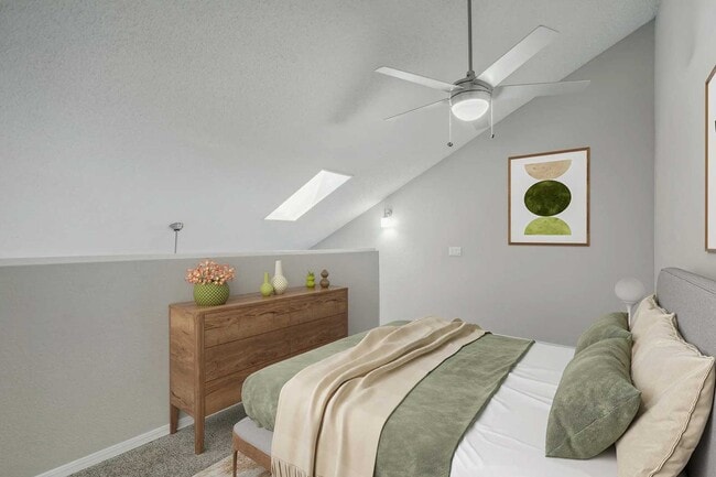 Bedroom with vaulted ceiling, skylight, ceiling fan, wood dresser, green accent bedding, and framed wall art - Walnut Creek at 122