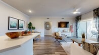 Located at 11100 4th St in Rancho Cucamonga, CA, this thoughtfully designed 2-bedroom, 2-bathroom residence offers a comfortable and modern living experience across a single floor. The open-concept kitchen and living area serves as the heart of the home, featuring a stylish kitchen equipped with crisp white shaker cabinetry, quartz countertops, a subway tile backsplash, stainless steel appliances including a range with hood vent and dishwasher, and wood-look flooring that flows seamlessly throughout the main living spaces. The living room is bright and welcoming, with crown molding details and sliding glass doors that open to a private outdoor patio, filling the space with natural light. Both bedrooms are generously proportioned, featuring plush carpeting, large windows that bring in ample daylight, and dedicated closet spaces. The primary bedroom offers a comfortable retreat with room for full-sized furnishings. The two bathrooms are clean and functional, each featuring tub-shower combinations, white vanities with quartz countertops, and wood-look tile flooring. A hallway connects the private and shared areas of the home efficiently. The overall ambiance is modern, neutral, and move-in ready, making it a well-rounded residence in a convenient Southern California location.