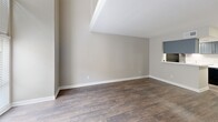Located at 10202 Challenger 7 Dr in Jacinto City, TX, this two-bedroom, one-bathroom unit is spread across two floors of nearly equal size, offering a functional and well-organized layout. The main floor houses the living room and kitchen, where dark hardwood-style flooring runs throughout. The living room is bright and open, featuring a large front-facing window that draws in natural light, a textured ceiling, and a staircase with white railings leading to the upper level. The kitchen is efficiently designed with gray shaker-style cabinetry, a stainless steel sink, black appliances including a refrigerator and dishwasher, and a light countertop with a pass-through breakfast bar. A louvered-door closet adjacent to the kitchen provides additional storage with built-in shelving.

Upstairs, the spacious primary bedroom features plush carpet flooring, a ceiling fan with light fixture, a window for natural light, and direct access to a dedicated closet. The second bedroom is similarly carpeted with a ceiling fan. The full bathroom includes a combined tub and shower with tiled surround and chrome fixtures. Both floors maintain a neutral, warm color palette throughout.