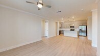 Located at 540 Hobbs Road in League City, Texas, this single-story 2-bedroom, 2-bathroom home offers a thoughtfully designed layout with clean, modern finishes throughout. Light wood-look flooring flows consistently across the living areas and bedrooms, complemented by neutral warm-toned walls and crisp white crown molding and baseboards that lend a polished, cohesive aesthetic.

The open kitchen and living room area forms the heart of the home. The kitchen is outfitted with gray shaker-style cabinetry, white quartz countertops, a subway tile backsplash, and a full suite of stainless steel appliances, including a range, over-the-range microwave, and refrigerator. The living area benefits from ceiling fans and natural light, creating a bright and comfortable environment.

The generously sized primary bedroom features crown molding, a ceiling fan, and windows that invite natural light. Its en-suite bathroom is a standout, offering a lengthy dual-sink vanity with white quartz countertops, a glass-enclosed walk-in shower with marble-style tile surround, and direct access to a walk-in closet. The second bedroom is well-proportioned with a double-door closet, while the second bathroom includes a tub-shower combination with elegant marble-style wall tile. The attached garage provides ample storage and parking space with direct interior access.