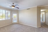 Located in Goodyear, AZ, this single-story, 3-bedroom, 2-bathroom home offers a well-designed layout with a seamless flow between living and dining areas. The open kitchen and living room combination serves as the heart of the home, featuring light wood cabinetry, black appliances including a refrigerator, range, and built-in microwave, tile flooring, a breakfast bar with pendant lighting, and track lighting overhead. A cozy tiled fireplace anchors the carpeted living area, which also includes crown molding, a ceiling fan, and a door leading directly to the private patio.

Each of the three bedrooms is carpeted and equipped with a ceiling fan and window with blinds, allowing natural light to fill the rooms. The primary bedroom includes a door to the exterior and crown molding detailing. Four closets throughout the home provide generous storage. The two bathrooms are finished with warm-toned tile surrounds in the tub/shower combinations, tile flooring, and wood-accented vanities with light countertops.

Neutral wall tones and consistent finishes throughout create a cohesive, move-in-ready atmosphere. Two hallways connect the home's spaces efficiently, completing this practical and comfortable single-floor layout.