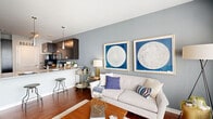 Located on East Market Street in downtown Indianapolis, this one-bedroom, one-bathroom unit offers a well-designed layout across a single floor. The open-concept living and kitchen area serves as the heart of the home, where rich hardwood floors flow throughout and large windows flood the space with natural light. Sliding glass doors provide direct outdoor access, enhancing the sense of openness.

The kitchen is outfitted with dark espresso cabinetry, black appliances including a range, microwave, refrigerator, and dishwasher, complemented by granite countertops and a peninsula with bar seating. Sleek pendant lighting above the peninsula adds a modern touch, while track lighting illuminates the cooking area.

The living room offers generous space and connects seamlessly to the kitchen, creating an ideal layout for both everyday living and entertaining. A dedicated office provides a functional, private workspace separate from the main living areas.

The bedroom features carpeted floors, a large window allowing ample natural light, and access to two closets for substantial storage. The bathroom includes a full tub-shower combination with white subway tile surround and granite vanity countertop. An in-unit laundry area adds everyday convenience. The unit's contemporary, neutral palette and modern finishes make it a polished and functional urban residence.