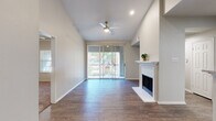 This thoughtfully designed 2-bedroom, 2-bathroom single-story residence offers a comfortable and functional layout across a well-utilized floor plan. An elegant arched entryway with wood-look flooring welcomes you inside and leads into the spacious living room, which features soaring vaulted ceilings, a ceiling fan, a classic white-mantled fireplace, and large sliding glass doors that flood the space with natural light and provide outdoor views. The kitchen is well-equipped with dark cabinetry, granite countertops, a subway tile backsplash, stainless steel appliances including a refrigerator, range, and microwave, and light tile flooring. Both bedrooms are carpeted and include ceiling fans and ample natural light from large windows. The primary bedroom offers a walk-in closet and direct access to its private bathroom. Each bathroom is finished with dark wood cabinetry, granite-topped vanities, wood-look flooring, and a tub-shower combination. The unit also includes a dedicated laundry area and two hallways that connect the spaces efficiently. Crown molding accents select rooms, adding a refined touch to the overall design.