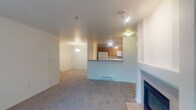 Located at 12320 SW Horizon Blvd in Beaverton, Oregon, this ground-floor unit offers a practical and comfortable single-level layout. The open living and dining area is anchored by a fireplace framed with a clean white surround and tile hearth, creating a welcoming focal point. Plush carpet extends throughout the living spaces, while a baseboard heating system provides warmth throughout. The kitchen is accessible via a pass-through breakfast bar counter and features warm wood-toned cabinetry, tile flooring, a double-basin sink, and white appliances including a refrigerator, electric range, microwave, and dishwasher — all illuminated by track lighting overhead. The bedroom is a well-proportioned, carpeted room filled with natural light from a large window with blinds, and includes a closet. The primary bathroom offers a wide vanity with an extended countertop, a large mirror, and a soaking tub with shower. A second bathroom provides a tub-shower combo, toilet, and tile flooring. The unit's neutral color palette, clean lines, and functional floor plan make it a well-organized and move-in ready space in the Beaverton community.