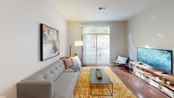This single-floor residence is thoughtfully designed with modern finishes and a functional open layout. The kitchen is a standout feature, showcasing granite countertops, warm honey-toned cabinetry, and a full suite of stainless steel appliances, including a gas range, built-in microwave, and refrigerator. A peninsula with additional counter space creates a natural transition into the living area, while a pendant light adds a polished touch overhead. Wood-look flooring runs throughout the main living spaces, lending warmth and continuity.

The living room is bright and inviting, benefiting from large sliding glass doors that open to a private balcony and fill the space with natural light and outdoor views. A wide window further enhances the airy feel of the room. Tucked conveniently between the kitchen and entryway is a stacked in-unit washer and dryer, adding everyday practicality.

The bedroom is generously sized with plush carpeting, a large window overlooking greenery, and ample wall space. The bathroom mirrors the kitchen's aesthetic with granite countertops, warm wood cabinetry, a well-lit vanity mirror, and a shower-tub combination. Neutral gray tones throughout the unit create a calm, cohesive atmosphere.