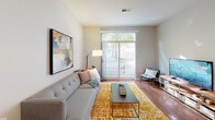This single-floor residence is thoughtfully designed with modern finishes and a functional open layout. The kitchen is a standout feature, showcasing granite countertops, warm honey-toned cabinetry, and a full suite of stainless steel appliances, including a gas range, built-in microwave, and refrigerator. A peninsula with additional counter space creates a natural transition into the living area, while a pendant light adds a polished touch overhead. Wood-look flooring runs throughout the main living spaces, lending warmth and continuity.

The living room is bright and inviting, benefiting from large sliding glass doors that open to a private balcony and fill the space with natural light and outdoor views. A wide window further enhances the airy feel of the room. Tucked conveniently between the kitchen and entryway is a stacked in-unit washer and dryer, adding everyday practicality.

The bedroom is generously sized with plush carpeting, a large window overlooking greenery, and ample wall space. The bathroom mirrors the kitchen's aesthetic with granite countertops, warm wood cabinetry, a well-lit vanity mirror, and a shower-tub combination. Neutral gray tones throughout the unit create a calm, cohesive atmosphere.