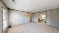 Located on Clairmont Road NE in the desirable Brookhaven neighborhood of Georgia, this single-floor home offers four bedrooms and one bathroom within a practical and well-organized layout. The living area features neutral-toned carpet and connects openly to the dining room, which is finished with warm hardwood-style flooring, a pendant light fixture, chair rail molding, and a window that brings in natural light. The updated kitchen is equipped with dark cabinetry, stainless steel appliances including a range, microwave, and dishwasher, complemented by a classic subway tile backsplash and light countertops. A convenient in-unit stacked washer and dryer is tucked into a dedicated nook off the main living area. The spacious primary bedroom features dual bifold closets and a ceiling fan, providing ample storage and comfort. Additional bedrooms are carpeted and include ceiling fans and windows with natural views. The shared bathroom is finished with hardwood-style flooring, a dark-framed vanity with a white countertop, a tub-shower combination, and a window for ventilation. The home's consistent neutral color palette and functional design make it a well-rounded living space in a convenient Brookhaven location.