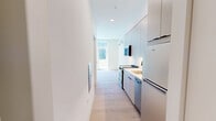 Located at 1529 N Fremont Street in Chicago's Lincoln Park neighborhood, this thoughtfully designed single-floor unit offers an efficient and contemporary living space. The layout consists of a combined kitchen and living room, a full bathroom, and a connecting hallway — each finished with a clean, modern aesthetic throughout.

The kitchen features sleek, flat-front cabinetry in a soft neutral tone, extending from floor to ceiling to maximize storage. Stainless steel appliances, a white quartz countertop, and an under-mount sink complete the functional and polished cooking area. Light wood flooring runs continuously through the space, lending warmth and visual continuity.

The living area is bright and open, benefiting from large floor-to-ceiling windows and a sliding glass door that leads directly to a private balcony. Abundant natural light fills the room, offering views of the surrounding courtyard and neighboring contemporary architecture. A wall-mounted mini-split system provides efficient climate control.

The bathroom showcases a bold design statement with full-surround checkerboard tiling in sage green and white, complemented by matte black hardware and a glass-enclosed walk-in shower with a built-in shelf and lighted mirror. The overall design of this unit balances compact efficiency with distinctive modern finishes, making it a well-appointed space in a prime Chicago location.