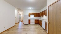 Located at 130 Marsh Ln in Elyria, Ohio, this single-floor home offers a practical and comfortable layout with two bedrooms, two bathrooms, and a thoughtfully arranged floor plan. Light-toned hardwood-style flooring runs throughout the main living areas, complemented by warm wood trim and baseboards that carry a consistent aesthetic across the home.

The combined dining and living room is a bright, open space anchored by a ceiling fan and a large sliding glass door fitted with vertical blinds, allowing abundant natural light and access to the private patio. The kitchen is well-appointed with rich, warm-toned wood cabinetry, ample counter space, and a full suite of white appliances including a range, refrigerator, and dishwasher.

The hallway connects the main living areas to the two bedrooms and two bathrooms. The generously sized primary bedroom includes walk-in closet space with wire shelving. The second bedroom features plush carpet flooring and a window with natural light. In total, four closets throughout the home provide excellent storage. Both bathrooms include a tub and clean, functional finishes.

The attached single-car garage features an automatic opener and concrete flooring. A dedicated utility room and a patio round out the home's functional offerings, making this a well-equipped and efficiently designed residence.