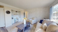 Located at 3309 Cowley Way in San Diego's 92117 neighborhood, this single-story residence offers a well-designed layout with a cohesive, light-filled aesthetic throughout. The living room is a welcoming focal point, featuring a striking textured stone accent wall, plush carpeting, and a built-in shelving and desk nook that provides both function and charm. Large windows invite abundant natural light, creating an airy and comfortable atmosphere. The kitchen is thoughtfully updated with crisp white cabinetry, granite-style countertops, a stainless steel gas range, and a full-size refrigerator, all set atop durable wood-look tile flooring. The primary bedroom is generously sized with a large picture window, plush carpet, and a mirrored sliding closet. A second bedroom offers its own window with natural light and carpet flooring, providing a cozy and versatile space. The full bathroom features a tiled shower-tub combination, wood-look flooring, and a window for natural ventilation. Throughout the home, a neutral, warm color palette ties each room together, creating a consistent and inviting living environment suited for comfortable everyday life in San Diego.