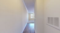 Located at 1124 Crosstown Way in Orlando, FL, this single-floor residence offers a practical and comfortable layout across a well-utilized footprint. A welcoming hallway with rich hardwood-style flooring leads into the heart of the home, where the kitchen, dining, and living areas flow together in an open-concept arrangement. The kitchen is a standout feature, showcasing dark espresso cabinetry, granite countertops, stainless steel appliances including a refrigerator, electric range, and microwave, and a peninsula with pendant lighting that doubles as a casual dining or prep space. Crown molding and track lighting add a refined touch overhead. The combined living and dining area is bright and open, with plush carpet and natural light filtering in. The bedroom is a comfortable retreat, featuring soft carpeting, two windows with blinds for natural light and privacy, and access to a spacious walk-in closet with wire shelving. The full bathroom features dark wood cabinetry with granite countertops, a glass-enclosed walk-in shower, and hardwood-style flooring. A dedicated in-unit laundry area with a full-size washer and dryer adds everyday convenience, complemented by two additional closets for ample storage throughout.