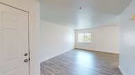 Located at 16410 SE 5th St in Vancouver, WA, this single-floor, 2-bedroom, 1-bathroom unit offers a well-organized and efficiently designed layout. Light wood-style flooring runs consistently throughout every room, lending a cohesive and clean aesthetic to the space.

The kitchen is a functional highlight, featuring white shaker cabinetry with brushed hardware, white quartz-style countertops, and a peninsula with a built-in sink — ideal for both meal preparation and casual dining. White appliances, including a refrigerator, electric range, and built-in microwave, are included. Ample upper and lower cabinet storage maximizes utility.

The open living area connects seamlessly to the kitchen and hallway, with neutral white walls and overhead lighting that create a bright, welcoming atmosphere. A hallway leads to both bedrooms, each featuring sliding double-door closets for generous storage. Windows fitted with vertical blinds allow natural light while maintaining privacy, with views of the surrounding neighborhood.

The bathroom is clean and straightforward, offering a full tub-shower combination with a showerhead, a white vanity with cabinetry, a toilet, and brushed nickel grab bar and fixtures. The consistent use of light tones and wood-style flooring carries through here as well, maintaining a unified look across the entire unit.