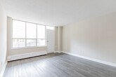 Located at 40 Tuxedo Court in Toronto's Scarborough neighbourhood, this one-bedroom, one-bathroom unit offers a well-organized, efficiently designed layout across a single floor. Neutral-toned walls and hardwood-style laminate flooring run throughout, creating a cohesive and clean aesthetic.

The living room is bright and inviting, featuring large floor-to-ceiling windows that flood the space with natural light and provide views of the surrounding streetscape. A baseboard heating unit runs beneath the windows, ensuring year-round comfort. The textured ceiling adds a classic character to the room.

The kitchen is thoughtfully appointed with white cabinetry featuring sleek bar-pull hardware, a stone-effect laminate countertop, a stainless steel sink, and a neutral tile backsplash — providing ample storage and counter space for everyday use.

The bedroom is a comfortable, well-proportioned room with its own window and built-in cabinetry for storage, complemented by the same laminate flooring found throughout the unit. A hallway connects the rooms efficiently, maintaining a logical and private flow.

The bathroom includes a white vanity with a stone-tone countertop, an inset sink, and a large mirror, keeping the space feeling open and functional. Overall, this unit presents a clean, modern, and practical living space in a well-established Toronto community.
