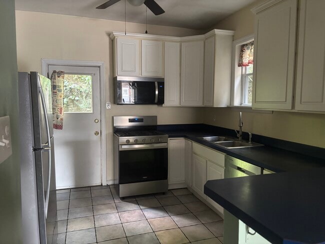Kitchen featuring new stainless steel refrigerator, gas range, microwave, and dishwasher - 4013 Dexter St
