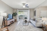 Located at 7450 Northrop Dr in Riverside, CA, this single-story 2-bedroom, 2-bathroom home offers a thoughtfully designed layout across a comfortable footprint. The open-concept living, dining, and kitchen area serves as the heart of the home, with light wood-style flooring, neutral gray tones, and ceiling fans throughout. The living room features a sliding glass door that invites natural light and provides direct access to a private patio. The galley-style kitchen is equipped with stainless steel appliances, including a gas range and built-in microwave, white shaker cabinetry, quartz-style countertops, and a deep single-basin sink. A dedicated dining area sits adjacent to the kitchen. The spacious primary bedroom features plush carpet, a ceiling fan, and a generous window with outdoor views, while the second bedroom mirrors the same comfortable aesthetic. Both bathrooms are finished with white cabinetry, quartz-style countertops, and tub-shower combinations with wood-look flooring. Three closets provide ample storage, and an in-unit laundry area adds everyday convenience. The entrance and hallway connect the spaces seamlessly, creating a cohesive and functional flow throughout the home.