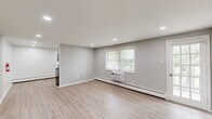 Located at 1 Harned Ave in Somerdale, NJ, this 2-bedroom, 1-bathroom unit offers a well-designed layout across a single floor, accessed via a staircase with a sleek black metal railing. The open main living area greets you with recessed lighting, light wood-style luxury vinyl flooring, and soft neutral gray walls that create a bright, clean atmosphere throughout.

Both bedrooms are comfortably sized, with the primary bedroom offering generous space. Each room features the same consistent wood-style flooring, neutral gray walls, white baseboard heating units, and windows that bring in natural light with views of surrounding greenery. The primary bedroom also includes a double-door closet with classic six-panel white doors, providing ample storage.

The hallway connects the bedrooms to the full bathroom, which is finished with large-format beige floor tiles, full tub-surround tiling in a warm taupe tone, a white vanity with cabinetry, and a window above the tub for added natural light. White six-panel doors are used consistently throughout the unit, reinforcing the clean, cohesive aesthetic. The overall design emphasizes a move-in-ready, modern finish with practical, durable materials suited for comfortable everyday living.