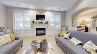 Located at 100 Avalon Park Cir in Asheville, NC, this single-floor community space offers a generously sized, open-concept layout designed for comfortable gathering and socializing. The interior is defined by elegant arched doorways and passageways that lend a refined architectural character throughout.

The main living area features a classic fireplace framed by a white mantel and flanked by large windows fitted with horizontal blinds, allowing ample natural light to fill the space. Recessed lighting and vaulted ceilings in select areas add to the sense of openness and airiness. Light-toned ceramic tile flooring flows seamlessly throughout, enhancing the bright, welcoming ambiance.

A well-appointed kitchen area includes rich cherry wood cabinetry, granite countertops, black appliances, and a curved breakfast bar with seating. Pendant lights hang above the bar, adding a stylish focal point. A dedicated dining area with seating for multiple guests sits adjacent, making the space highly functional for group use.

The layout also incorporates a reception-style counter framed by a prominent arched surround, adding a polished, professional touch. Overall, the space presents a clean, neutral palette accented with warm wood tones, offering a versatile and inviting environment.