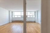 Located at 1005 Lansdowne Avenue in Toronto's vibrant Corso Italia neighbourhood, this one-bedroom, one-bathroom unit offers a clean, functional layout across a single floor. The interior is defined by light-toned hardwood flooring that runs throughout, crisp white walls, and large windows that fill the space with natural light while framing views of the surrounding urban skyline.

The living room is an open, well-proportioned space with a floor-to-ceiling window wall featuring a baseboard heating unit beneath, providing both comfort and a clear city outlook. The room's simple, uncluttered design creates a versatile canvas for a variety of furniture arrangements.

The bedroom is a comfortable, private retreat with its own window offering natural light and urban views. A set of mirrored sliding closet doors adds both practical storage and a sense of expanded space, reflecting the light hardwood floors and bright surroundings.

The bathroom is finished with neutral large-format tiles and features a deep soaker tub equipped with a sleek chrome rain shower system and handheld attachment, offering a refined and functional bathing experience.

Overall, the unit presents a bright, minimalist aesthetic well-suited to urban living, with consistent finishes, ample natural light, and a practical layout throughout.