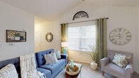 Located at 1 Village Gate Blvd in Delaware, Ohio, this single-floor residence offers a well-designed layout with a variety of comfortable living spaces. The living room is a welcoming area highlighted by vaulted ceilings that enhance the sense of openness, soft carpeting underfoot, and a large window dressed with grommet-panel curtains that invite natural light. A secondary room provides flexible space, ideal for a home office or additional lounge area, also featuring plush carpet and a bright window.

The kitchen is efficiently arranged in a galley style with warm wood cabinetry, gray laminate countertops, light wood-look flooring, and white appliances including a gas range, refrigerator, and dishwasher. A peninsula counter variant is also present in the space, opening toward the dining and living areas beneath vaulted ceilings.

The bedroom is generously sized with soft carpet, a broad window allowing natural light, and access to a dedicated walk-in closet with built-in shelving rods. The bathroom is neatly appointed with a tub-shower combination, a wood-trimmed vanity, granite-style countertop, and a large mirror. Throughout the residence, neutral tones and consistent finishes create a cohesive and comfortable living environment.