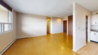 Located at 288 Mount Albion Rd in Hamilton, Ontario, this 2-bedroom, 1-bathroom unit offers a practical and well-laid-out single-floor plan with a comfortable sense of space throughout. The combined kitchen and living room serves as the heart of the unit, with large picture windows along one wall that flood the area with natural light and frame outdoor views. A sliding glass door leads directly to a private balcony, extending the living space outdoors. The kitchen features white cabinetry with ring-pull hardware, a stone-effect countertop, and light hardwood-style flooring, providing a clean and functional workspace. The living area is finished with warm-toned vinyl tile flooring and baseboard heating, consistent throughout the unit. Both bedrooms are well-proportioned, with the primary bedroom offering generous room to furnish comfortably. Each bedroom is fitted with sliding wood-panel wardrobe doors for ample storage. The second bedroom benefits from its own window with outdoor views. The bathroom is finished with full-height white ceramic tile surrounding a bathtub and shower combination, complemented by chrome fixtures. Neutral warm beige tones throughout the unit create a calm, cohesive ambiance.