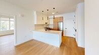 This thoughtfully designed residence at 601 Sayre Ave in Perth Amboy, NJ offers a clean, modern aesthetic across a well-planned single-floor layout with 2 bedrooms and 3 bathrooms. Light hardwood flooring flows seamlessly throughout, complementing the bright white walls and creating a warm, cohesive atmosphere.

The open-concept living, dining, and kitchen area serves as the heart of the home. The contemporary kitchen is outfitted with warm wood cabinetry, crisp white upper cabinets, a textured tile backsplash, stainless steel appliances, and a central island with a matte black faucet — all illuminated by a trio of sleek pendant lights.

Both bedrooms are generously proportioned and filled with natural light from large windows with views of the surrounding neighborhood. The rooms feature the same light hardwood flooring and clean white walls, offering a calm and versatile canvas. Two closets provide ample storage.

The three bathrooms are distinctively finished. One features a floating wood vanity with a white quartz countertop, a backlit oval mirror, and textured tile walls. Another showcases a full soaking tub and shower enclosure lined with rich green glazed tile and black hardware accents. A dedicated laundry room adds everyday convenience to this well-appointed home.