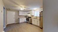 Located at 59 New Ludlow Rd in Chicopee, Massachusetts, this single-floor residence offers a clean, updated interior designed for comfortable everyday living. The kitchen is a standout feature, showcasing white shaker-style cabinetry, light granite countertops, and a full suite of stainless steel appliances including a range, dishwasher, and refrigerator. A ceiling fan overhead and wood-look vinyl flooring complete the functional yet stylish space, which benefits from natural light through a window fitted with blinds. The living area is generously sized, carpeted in neutral gray tones, and equipped with a wall-mounted air conditioning unit and baseboard heating, ensuring year-round comfort. Multiple bedrooms continue the neutral palette with plush carpeting, baseboard heaters, and windows that bring in natural light. The bathroom is elegantly finished with large-format marble-look tile covering both the floors and walls, a soaking tub with shower, a granite-topped vanity with white cabinetry, and a bright window. Textured ceilings are consistent throughout the home, and the overall color scheme of warm grays and whites creates a cohesive, move-in-ready atmosphere throughout this Chicopee residence.