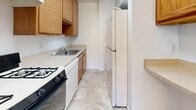 This contemporary apartment offers a blend of comfort and functionality. The open-plan living area is adorned with plush wall-to-wall carpeting, creating a cozy ambiance. Large windows and a sliding glass door leading to a private balcony flood the space with natural light, enhancing the airy feel.

The kitchen, while compact, is efficiently designed with wooden cabinetry, white appliances, and a practical layout. It features a gas stove, dishwasher, and ample counter space for meal preparation.

The bathroom showcases a clean, white aesthetic with a combination tub-shower unit, toilet, and vanity. Tiled flooring adds a touch of durability and style.

Bedrooms are generously sized, with large windows and spacious closets featuring wire shelving systems. The neutral color palette throughout allows for personalization.

Additional amenities include in-unit laundry facilities and central heating and cooling systems. The apartment's layout, as seen in the 3D floor plan, reveals a well-thought-out design that maximizes space and functionality.

Overall, this apartment presents a modern living space with a focus on comfort and practicality, ideal for those seeking a contemporary urban lifestyle.
