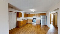 Located at 802 Dickinson Ave in Ames, Iowa, this single-story, 3-bedroom, 2-bathroom home offers a practical and comfortable layout across one level. The combined kitchen and living room serves as the heart of the home, featuring warm honey-toned hardwood-style flooring, a textured ceiling, and a ceiling fan. The living area is bathed in natural light from a large sliding glass door with vertical blinds that opens to an outdoor view. The kitchen is well-appointed with an abundance of warm oak cabinetry, light countertops, a double sink, a stainless steel dishwasher, a stainless steel refrigerator, and an electric range with hood. A dedicated laundry room adds everyday convenience. The three bedrooms are carpeted and bright, each offering a comfortable, functional space. The primary bedroom is generously sized and connects to additional closet access. Secondary bedrooms feature windows with neighborhood views. Two full bathrooms are finished with oak vanity cabinetry, light countertops, hardwood-style flooring, and a tub/shower combination. Six closets distributed throughout the home provide ample storage. The hallway connects all rooms in a cohesive single-floor flow, making this home an efficient and livable space in a residential Ames neighborhood.