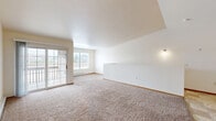 Located at 1654 W Evergreen Dr in Appleton, Wisconsin, this single-floor, two-bedroom, one-bathroom home offers a comfortable and functional layout. The spacious living room is a standout feature, boasting vaulted ceilings, plush carpeting, and a sliding glass door that fills the room with natural light while providing access to the outdoors. A ceiling fan adds to the room's comfort, and the open feel is further enhanced by an airy, split-level design with a staircase and railing detail.

The kitchen is well-equipped with warm oak cabinetry, dark granite-style countertops, tile flooring, and white appliances including a refrigerator, electric range, and dishwasher — providing ample storage and workspace for everyday cooking.

The primary bedroom is generously sized, featuring soft carpeting, a wide mirrored sliding-door closet, and a window that brings in natural light. The second bedroom also offers carpeted flooring, a window with outdoor views, and access to a dedicated walk-in closet with built-in shelving.

The full bathroom is finished with tile flooring, a vanity with matching countertop, and a full tub-shower combination. A dedicated laundry room accommodates a full-size washer and dryer side by side, with an overhead utility shelf for added storage convenience.