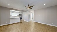 Located at 11819 Eucalyptus Ave in Hawthorne, CA, this single-story 2-bedroom, 2-bathroom home offers a clean, modern aesthetic throughout. The open-concept living and kitchen area is anchored by warm wood-look flooring, recessed lighting, and a ceiling fan, creating a bright and airy atmosphere. The kitchen is well-appointed with crisp white shaker cabinets, a central island with a white quartz countertop, stainless steel appliances including a gas range and microwave, and a window above the sink that brings in natural light. A dedicated pantry provides additional storage. The spacious primary bedroom features a ceiling fan, a door with outdoor access, and natural light through slatted blinds, while the second bedroom offers a wide window with neighborhood views and its own closet. Both bedrooms are finished with the same wood-look flooring and neutral wall tones. The bathrooms are thoughtfully designed — one features a soaking tub surrounded by elegant marble-style tile with a decorative mosaic accent border, while the other offers a clean vanity with a stone-look countertop. A generously sized utility/laundry room with white cabinetry, a double stainless steel sink, and a bright window rounds out this well-designed home.