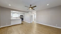 Located at 11819 Eucalyptus Ave in Hawthorne, CA, this single-story 2-bedroom, 2-bathroom home offers a clean, modern aesthetic throughout. The open-concept living and kitchen area is anchored by warm wood-look flooring, recessed lighting, and a ceiling fan, creating a bright and airy atmosphere. The kitchen is well-appointed with crisp white shaker cabinets, a central island with a white quartz countertop, stainless steel appliances including a gas range and microwave, and a window above the sink that brings in natural light. A dedicated pantry provides additional storage. The spacious primary bedroom features a ceiling fan, a door with outdoor access, and natural light through slatted blinds, while the second bedroom offers a wide window with neighborhood views and its own closet. Both bedrooms are finished with the same wood-look flooring and neutral wall tones. The bathrooms are thoughtfully designed — one features a soaking tub surrounded by elegant marble-style tile with a decorative mosaic accent border, while the other offers a clean vanity with a stone-look countertop. A generously sized utility/laundry room with white cabinetry, a double stainless steel sink, and a bright window rounds out this well-designed home.