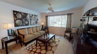 The Sherwood is a single-story, 2-bedroom, 2-bathroom residence designed for comfortable everyday living. The layout flows naturally from the living area through to the dining space, kitchen, and bedrooms, offering a well-organized and functional floor plan.

The living room serves as the central gathering space, featuring carpet flooring, a ceiling fan, and a broad window dressed with grommet-panel curtains that allow natural light to filter in with views of the outdoors. The dining area is positioned adjacent to the living space and accommodates a full dining table setup, with a closet nearby adding practical storage.

The kitchen is galley-style, equipped with wood-toned cabinetry, dark countertops, hardwood-style flooring, a full-size refrigerator, and a coil-burner range with overhead ventilation. Track lighting and ample counter space make the kitchen both functional and efficient.

Each bedroom offers carpet flooring, a ceiling fan, and windows with outdoor views. The primary bedroom includes direct access to a private bathroom and a walk-in closet, providing added convenience. Both bathrooms feature hardwood-style flooring, vanities with granite-style countertops, and tub-shower combinations. One bathroom also includes an in-unit washer connection, adding further practicality to the residence.