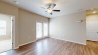 Located at 311 Hope Bird Lane in Longs, SC, this well-designed two-bedroom, two-bathroom home offers a comfortable and functional single-floor layout. The living area features warm hardwood-style flooring, neutral beige walls, and a ceiling fan with light fixture, creating a bright and airy atmosphere. French doors lead to an outdoor view, filling the space with natural light. The kitchen is a standout, equipped with white shaker cabinetry, granite countertops, stainless steel appliances, a kitchen island with pendant lighting, and a sink—ideal for both everyday cooking and entertaining. A dedicated laundry room houses a full-size top-loading washer and dryer with overhead wire shelving for added storage. The primary bedroom is a comfortable retreat with plush carpet, a ceiling fan, large windows offering outdoor views, and a walk-in closet. The second bedroom also features carpet flooring and clean neutral tones. Both bathrooms are finished with white shaker vanities, granite countertops, large mirrors, and hardwood-style flooring; one includes a tub-shower combination. A well-organized hallway with multiple closets adds practical storage throughout. The home's cohesive, modern finishes and thoughtful layout make it a move-in-ready residence.