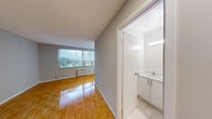 Located at 110 Marlee Avenue in Toronto's vibrant Fairbank neighbourhood, this studio unit offers a practical and efficiently designed single-floor layout. The open living area is characterized by warm parquet flooring laid in a classic herringbone-style pattern, neutral grey walls, and clean white baseboards that together create a bright, understated aesthetic. A large window fitted with vertical blinds allows generous natural light to fill the space, contributing to an airy feel. A baseboard radiator provides in-unit heating. The kitchen is neatly appointed with white upper and lower cabinetry, marble-look countertops, a stainless steel sink, and white appliances including an electric coil range and a full-size refrigerator. Light tile flooring in the kitchen provides a clean contrast to the parquet in the living area. The bathroom features a full soaker tub with an overhead shower, light beige wall tiling, a toilet, and a mirrored medicine cabinet, maintaining a simple and functional design. A dedicated closet provides essential storage. The unit is well-suited for individuals seeking a manageable, self-contained space in a central Toronto location.