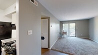 Located at 13607 Riverway Dr in Chesterfield, MO, this single-floor unit offers a practical and comfortable layout with neutral grey tones throughout. The entry opens into a generous living area finished with wood-look flooring that transitions into plush carpeting, creating a warm and inviting atmosphere. A ceiling fan adds comfort to the space, while sliding glass doors flood the room with natural light and provide direct access to a private balcony with pleasant outdoor views.

The galley-style kitchen is equipped with black appliances, including a refrigerator and range, alongside grey cabinetry and a sink with under-cabinet lighting, offering a functional cooking space. A dedicated hallway leads to additional storage, including a built-in shelving closet, keeping the unit well-organized.

The bedrooms are carpeted and bathed in natural light from windows fitted with blinds. Generous sliding-door closets provide substantial storage. The bathroom is clean and well-appointed, featuring a full tub and shower combination, a single vanity with a granite-style countertop, and wood-look flooring. Throughout the unit, consistent grey paint, white trim, and thoughtful layouts contribute to a cohesive and functional living environment.