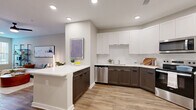 Located at 4020 Chartwell Court in Spring Hill, Tennessee, this thoughtfully designed one-bedroom, one-bathroom residence offers a functional and stylish single-floor layout. The open-concept kitchen and living area serves as the heart of the home, featuring a two-tone cabinet design with white upper cabinets and dark wood-toned lower cabinets, quartz countertops, stainless steel appliances, and a peninsula with bar seating — ideal for casual dining and entertaining. Wood-look flooring runs throughout, adding warmth and continuity across the space. The living area provides a comfortable, light-filled retreat with natural light streaming through large windows. The bedroom is a well-proportioned private sanctuary, complete with a ceiling fan, a natural light-filled window with an outdoor view, and direct access to a walk-in closet. The full bathroom features marble-style tile surrounds in the soaking tub and shower combination, complemented by dark wood cabinetry and quartz countertops. Three closets total provide generous storage throughout. A dedicated laundry area adds everyday convenience. The neutral color palette and modern design elements create a cohesive, contemporary ambiance throughout this efficiently designed Spring Hill residence.