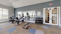 Located on Offshore Drive in East Amherst, NY, this well-equipped fitness center offers a comprehensive workout environment across a single floor. The space is bathed in natural light, thanks to an abundance of large windows fitted with white blinds that frame views of the surrounding outdoor greenery. Vaulted ceilings in portions of the room enhance the sense of openness and airiness throughout.

The cardio area is a standout feature, lined with multiple treadmills, elliptical machines, and stationary bikes — each equipped with individual screens for entertainment during workouts. A wall-mounted flat-screen television provides additional viewing options for users. The strength training section includes a tiered dumbbell rack stocked with a full range of free weights, complemented by a weight bench for targeted exercises.

A large wall-length mirror runs along one side of the room, visually expanding the space and allowing users to monitor their form. The flooring consists of a durable, patterned carpet tile in a mix of blue and brown tones, adding both function and style to the environment. A French door with glass panels connects to an adjacent area, adding architectural charm. The overall ambiance is clean, modern, and functional, making this fitness center a practical and inviting facility for daily exercise routines.