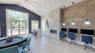 Located at 4255 Kittredge St in Denver, Colorado, this single-story community clubhouse offers a thoughtfully designed gathering space with a range of amenities. The open-concept layout is anchored by soaring vaulted ceilings, light wood-look tile flooring, and an abundance of natural light streaming through large windows and glass doors that frame views of the surrounding outdoor area.

The game room is a standout feature, offering a round poker table with upholstered seating, a shuffleboard table, and direct access to the outdoor pool area via French doors — all set against bold navy blue accent walls and bathed in natural light.

Adjacent to the game room, a well-appointed business center provides multiple computer workstations illuminated by pendant lighting, set against a striking stacked-stone accent wall. A sleek, floor-to-ceiling tile surround frames a linear fireplace, serving as an architectural centerpiece that ties the workspace and lounge areas together.

A compact but fully equipped kitchen features white cabinetry, stainless steel appliances, and a quartz-topped breakfast bar — ideal for hosting community events or casual gatherings. Throughout the space, a cohesive color palette of navy, grey, and warm stone tones creates a modern yet welcoming ambiance, making this clubhouse a versatile hub for both productivity and recreation.
