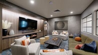 This theater space is designed as a sophisticated media lounge, combining comfortable viewing with contemporary interior design. The focal point of the room is a large flat-screen television mounted within a built-in wood-paneled entertainment wall, flanked by open shelving displaying decorative objects and media accessories. A soundbar and media console with open storage compartments complete the entertainment setup, providing both functionality and visual appeal.

The seating arrangement is thoughtfully curated, featuring a mix of plush light gray accent chairs, an olive-toned sofa, and a tufted dark leather ottoman that doubles as a central coffee table. Two cylindrical upholstered stools provide flexible additional seating. Colorful accent pillows in warm orange, rust, and blue tones add vibrancy against the neutral furnishings.

The room's walls are finished in a textured concrete-style treatment in a deep gray tone, lending an urban, contemporary ambiance. Large framed artwork, including an abstract circular piece and vibrant multi-panel prints, adds artistic character. Interior windows with black steel frames allow views into adjacent spaces, while recessed lighting provides a warm, even illumination. The patterned blue and gray area rug anchors the seating arrangement and reinforces the space's modern aesthetic.