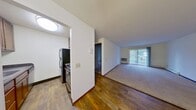 This 570 square foot apartment in Fitchburg, WI, offers a practical living space with two bedrooms and one bathroom. The single-story layout maximizes efficiency, with the primary bedroom boasting a generous 330 square feet. The kitchen showcases modern appliances, including a stainless steel refrigerator and dark countertops, complemented by wooden cabinetry. The bathroom features a standard tub-shower combination and tiled flooring. Throughout the apartment, a mix of carpeting and hardwood floors adds warmth and character. Large windows in the living area and bedrooms allow ample natural light, while a sliding glass door leads to an outdoor space. The apartment's neutral color palette and clean lines create a bright, airy atmosphere. Built-in closets with dark wooden doors provide storage solutions. A ceiling fan in the main living area aids in air circulation. This compact yet well-designed space offers comfortable living in a convenient location.