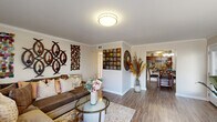 Located in Harvey, Louisiana, this single-story 2-bedroom, 2-bathroom residence offers a functional and stylish layout across a comfortable footprint. The living room serves as the heart of the home, featuring wood-look flooring, crown molding, and a sliding glass door that invites natural light and outdoor views. The adjacent dining area is defined by a pendant chandelier and flows seamlessly into the kitchen, which is equipped with rich dark wood cabinetry, granite-style countertops, a tile backsplash, a kitchen island, and black appliances. The primary bedroom features plush carpeting, multiple windows, and a serene, restful ambiance. The second bedroom also offers carpeted flooring and access to a walk-in closet, making it a versatile and practical space. Both bathrooms are efficiently designed, with one featuring a shower-tub combination. Two hallways connect the rooms, contributing to a logical and easy-to-navigate floor plan. Throughout the home, wood-look flooring in the common areas and soft carpet in the bedrooms provide a cohesive yet comfortable aesthetic, making this residence a well-balanced blend of function and warmth.