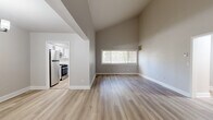 Located at 23 Lake Shore Dr in Watervliet, NY, this single-floor, 3-bedroom, 1-bathroom home offers a well-organized layout with a comfortable blend of modern updates and practical design. The living area immediately impresses with its dramatic vaulted ceilings and light-toned hardwood flooring, creating an open and airy atmosphere. A wide window frames natural light throughout the main living space, enhancing the neutral gray and white color palette. A chandelier-lit dining area connects seamlessly to the main living zone. The updated kitchen features two-tone cabinetry — white upper cabinets paired with gray lowers — complemented by a white subway tile backsplash, stainless steel appliances including a refrigerator, gas range, and dishwasher, and a window above the sink. The full bathroom is clean and bright, finished with white tile surrounding the tub/shower combo and matte black fixtures paired with a gray vanity. The generously sized primary bedroom is carpeted and includes multiple closets, offering abundant storage. The two additional bedrooms are also carpeted, each with textured ceilings and ample natural light. Four closets total and a dedicated utility room round out the functional layout of this well-maintained home.