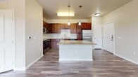 This contemporary 670 square foot apartment in Englewood, CO, offers a harmonious blend of style and functionality. The open-concept design seamlessly integrates the living room and kitchen, creating a spacious feel. The kitchen is a standout feature, boasting rich wooden cabinetry, sleek stainless steel appliances, and elegant granite countertops. A central island provides additional workspace and casual dining options.

The bedroom, measuring 170 square feet, is generously sized and features plush carpeting and large windows that flood the space with natural light. An adjoining walk-in closet offers ample storage with built-in shelving systems. The bathroom continues the modern aesthetic with a granite-topped vanity and wood-look flooring.

Throughout the apartment, a neutral color palette of warm beiges and whites creates a calming atmosphere. The living areas and kitchen showcase durable wood-look flooring, while the bedroom's carpeting adds comfort. Large windows in every room, including a corner window feature, provide abundant natural light and views of the surrounding area.

This well-designed apartment efficiently utilizes its 670 square feet to provide comfortable, stylish living in a prime Englewood location.
