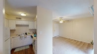This single-story, one-bedroom, one-bathroom unit presents a thoughtfully organized layout across a comfortable footprint. The living area is carpeted and features a ceiling fan with light fixture, neutral-toned walls, and a sliding glass door that opens to a private balcony with outdoor views, allowing natural light to fill the space. Adjacent to the living room, an in-unit laundry area accommodates a full-sized washer and dryer.

The kitchen is efficiently designed with white cabinetry, light countertops, a double-basin sink, a dishwasher, and a coil-burner electric range with overhead ventilation. Wood-style flooring grounds the kitchen and adds visual contrast to the carpeted areas throughout the unit.

The bedroom offers generous proportions, with a ceiling fan, a window providing natural light and outdoor views, and a sliding-door closet with a full-width hanging rod for ample storage.

The bathroom includes a single-sink vanity with a large mirror, a tub/shower combination, and wood-style flooring. Textured ceilings are consistent throughout the unit, and the overall color palette of soft neutrals creates a cohesive, functional living environment.