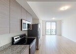 Located at 1500 Miami Pl in the heart of Miami, FL, this contemporary single-floor residence offers a clean, modern aesthetic throughout. The open-concept living and kitchen area is anchored by light wood-tone flooring that extends seamlessly through the space, creating a bright and cohesive feel. Floor-to-ceiling sliding glass doors flood the living area with natural light while framing sweeping views of the Miami skyline and surrounding cityscape.

The kitchen is outfitted with a full suite of stainless steel appliances, including a refrigerator with ice maker, electric range, built-in microwave, and dishwasher. Warm wood-toned cabinetry pairs with granite countertops to strike a balance between modern and natural materials. A stacked washer and dryer unit is conveniently tucked behind bi-fold doors nearby.

The bedrooms feature the same light hardwood flooring and are well-served by large windows that capture city views and bring in generous natural light. Each bathroom is finished with marble-style tile walls and flooring, granite-topped wood vanities, and chrome fixtures. A large mirror above the vanity enhances the sense of space. The overall design is clean, minimalist, and well-appointed, making this an ideal urban residence in one of Miami's most central locations.
